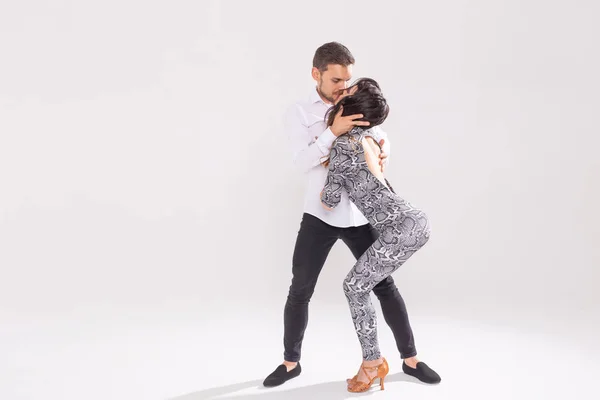 Страстная пара танцует социальный данс кизомба или бачата или семба или тараксия на белом фоне с копировальным пространством — стоковое фото