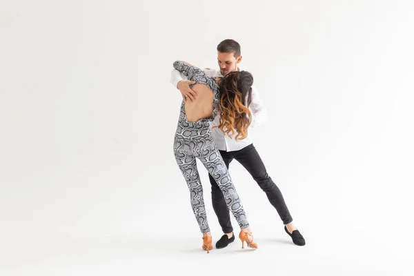 Mladý pár tančí latinský tanec Bachata, Merengue, salsa, kizomba. Dvě elegance se pózují na bílém pozadí s prostorem pro kopírování — Stock fotografie