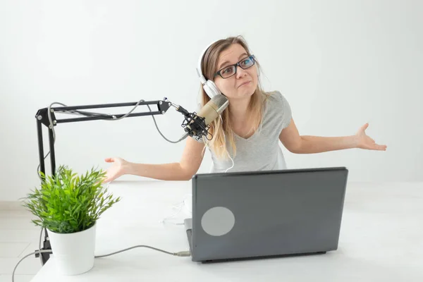 Radio, DJ, blogging and people concept - Smiling woman sitting in front of microphone, host at radio
