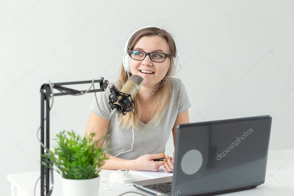 Radio, dj, blogger and people concept - young woman presenter working on the radio studio and talking on the microphone