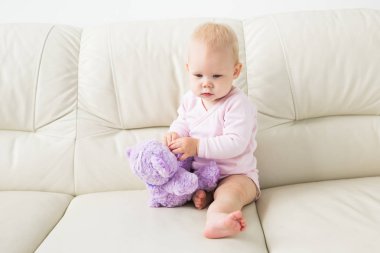 Çocuklar, bebek ve çocukluk konsepti - güzel gülümseyen bebek oturma