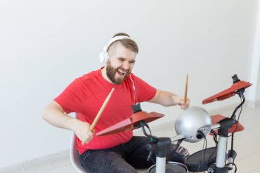 Müzik, hobi ve insan kavramı - genç adam davulcu elektronik davul çalıyor