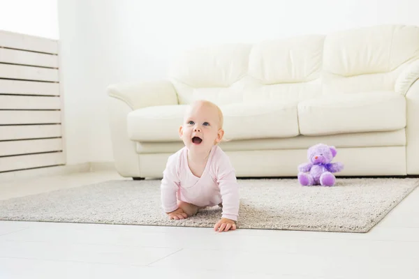 Kindheit, Kinder und Babyhood-Konzept - lustiges Baby-Mädchen zu Hause krabbeln — Stockfoto