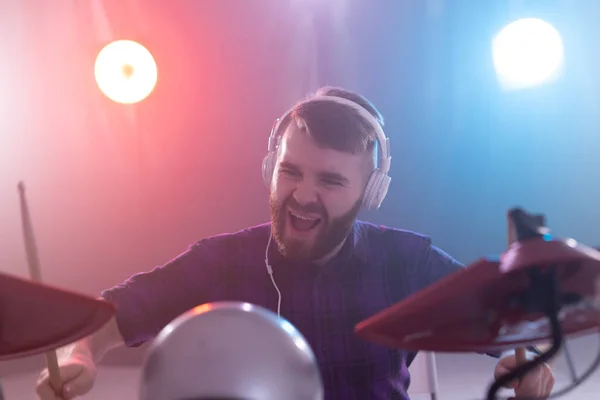 Mensen, muziek en hobby concept-emotionele man speelt drums op het podium. — Stockfoto