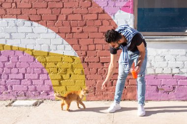 Dostluk ve evcil hayvan kavramı - Sevimli kedi açık yakışıklı genç adam