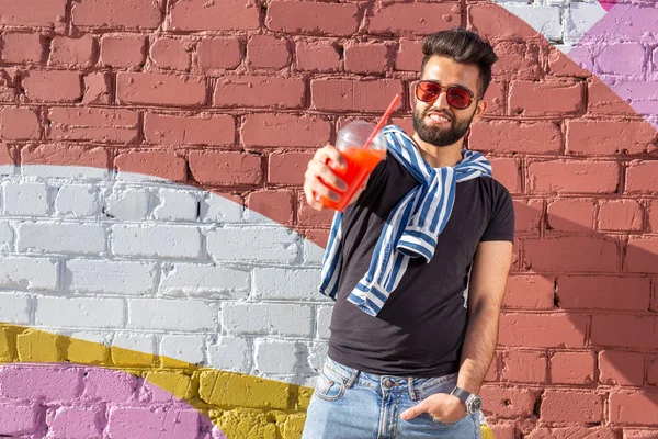 콧수염과 수염을 가진 귀여운 세련된 아랍 젊은 남성 힙스터와 빨대와 주스를 마시는 안경을 착용. 여름 방학 컨셉. — 스톡 사진