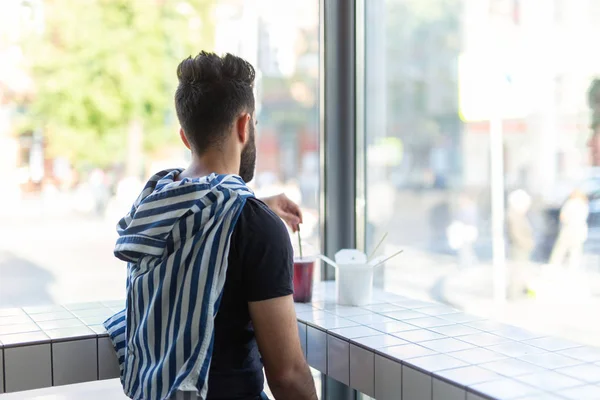 Pozytywny młody stylowy facet picie soku w kawiarni podczas przerwy w pracy. Koncepcja odpoczynku i zdrowej przekąski. — Zdjęcie stockowe