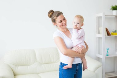 Anne küçük bebeğe sarılır. Kızı ile mutlu kadın