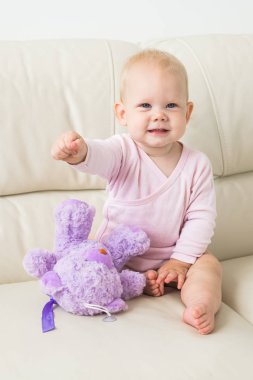 Çocuklar, bebek ve çocukluk konsepti - güzel gülümseyen bebek oturma