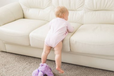 Çocuk, çocukluk ve çocuk kavramı - Kanepe yakınında sevimli kız bebek Portresi