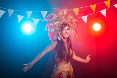 Karnaval, oryantal dans ve tatil konsepti - Altın kostüm giyen ve gülümseyen güzel kadın samba dansçısı