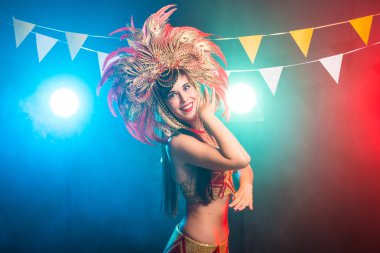 Karnaval, oryantal dans ve tatil konsepti - Altın kostüm giyen ve gülümseyen güzel kadın samba dansçısı