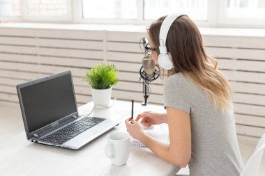 Radyo, Dj, bloglama ve insan kavramı - Gülümseyen kadın mikrofon önünde oturan, radyo da ev sahibi