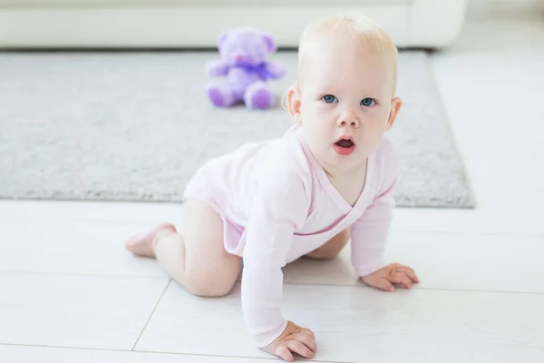 Retrato de un lindo bebé gateando y riendo en el suelo en casa — Foto de Stock