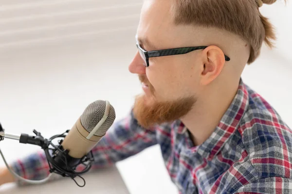 Radio, DJ, blogging y el concepto de la gente - Primer plano del hombre sonriente sentado frente al micrófono, host en la radio — Foto de Stock