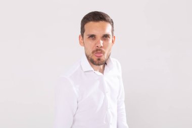 Sakallı ve bıyıklı yakışıklı komik adam beyaz arka planda dilini gösteriyor. Duygu ve duygular.