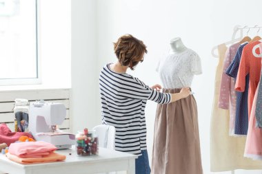 Terzi, Küçük Ölçekli İşletmeler, moda tasarımcısı ve terzi konsepti - Çalışma süreci, tasarımcı manken üzerinde kıyafet süsler