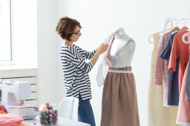 Moda tasarımcısı, terzi ve Küçük Ölçekli İşletmeler kavramı - kadın terzi bir manken süsler