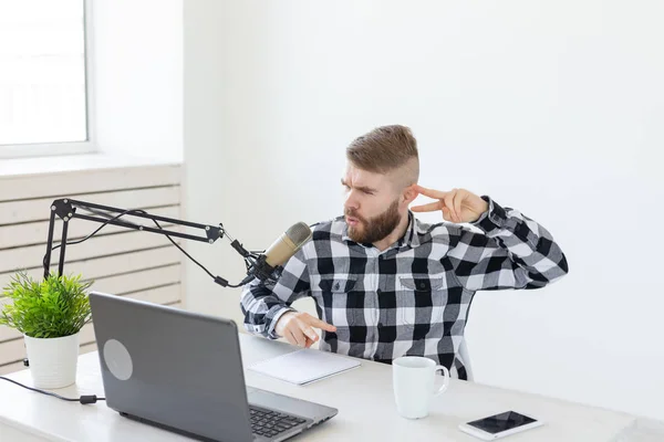 Anfitrión de radio, streamer y blogger concepto - Hombre guapo trabajando como locutor de radio en la estación de radio sentado frente al micrófono — Foto de Stock