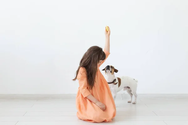 애완 동물, 어린이와 개 개념 - 강아지와 함께 노는 드레스의 어린 소녀 — 스톡 사진