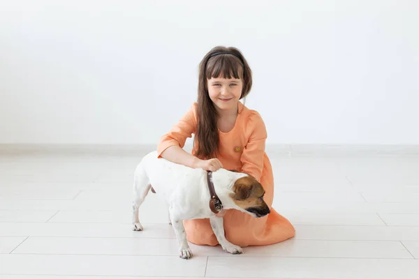 Barn och husdjur ägare Concept-liten barnflicka sitter på golvet med söt valp Jack Russell Terrier — Stockfoto