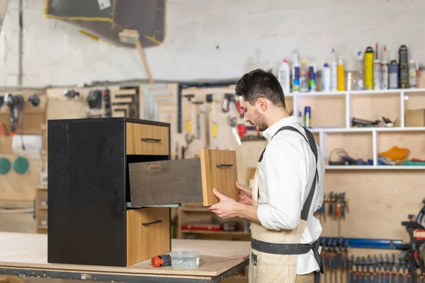 Möbelfabrik, små företag och folk koncept-ung man som arbetar på möbelproduktion — Stockfoto