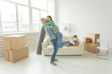 Denim pantolon genç çift hareket sırasında yeni dairede sevincini kucaklayan. Yeni konut için housewarming ve kredi kavramı.