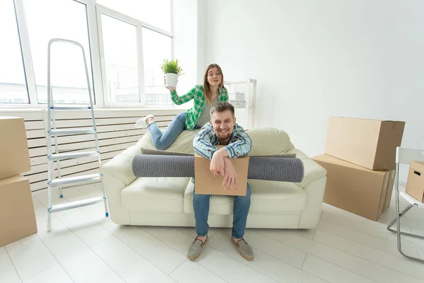 stock image Cheerful young couple rejoices in moving to a new home laying out their belongings in the living room. Concept of housewarming and mortgages for a young family