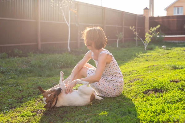 Jeune femme avec son chien Jack Russell terrier jouer sur l'herbe à l'extérieur — Photo