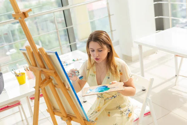 Pintura clases de arte. cursos de dibujo. habilidades imaginación e inspiración. Encantadora chica estudiante creando imagen en caballete . —  Fotos de Stock