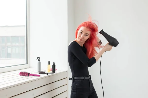 Friseur, Stil, People-Konzept - Frau föhnt sich ihre gefärbten Haare trocken — Stockfoto