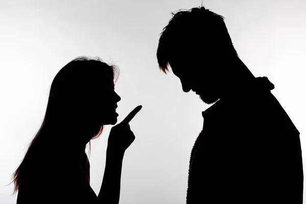 Konsep agresi dan pelecehan - pria dan wanita mengekspresikan kekerasan dalam rumah tangga di siluet studio yang terisolasi dengan latar belakang putih . — Stok Foto