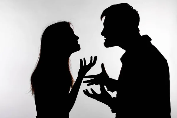 Koncepcja agresji i nadużyć-mężczyzna i kobieta wyrażająca przemoc domową w studio sylwetka na białym tle. — Zdjęcie stockowe