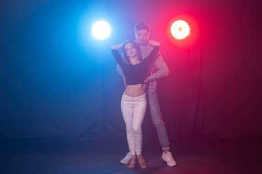 Sosyal dans, bachata, salsa, kizomba, zouk ve tango kavramı - Erkek ışıklar üzerinde dans ederken kadın kucaklar