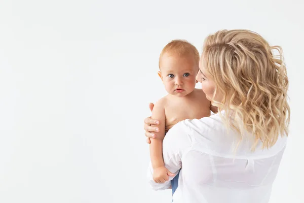 Conceito de infância, maternidade e família - Mãe feliz retrato segura seu bebê em fundo branco com espaço de cópia — Fotografia de Stock