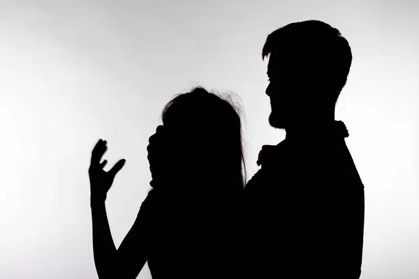 Concetto di violenza e abuso domestico - Silhouette dell'uomo che picchia la donna indifesa — Foto Stock