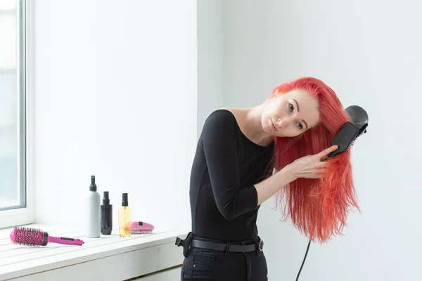 Kuaför, güzellik salonu ve insan kavramı - beyaz arka plan üzerinde saç kurutma makinesi ile genç kadın saç stilisti — Stok fotoğraf