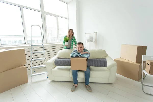Deslocalização, imobiliário e conceito em movimento - Jovem casal alegre se mudando para sua nova casa — Fotografia de Stock