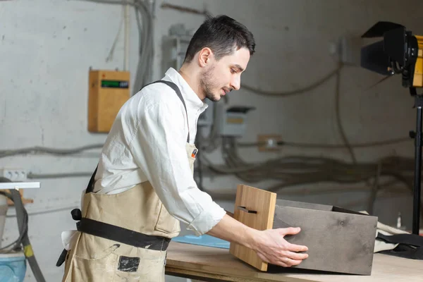 Fábrica de muebles y concepto de pequeñas y medianas empresas - El hombre recoge detalles de muebles —  Fotos de Stock