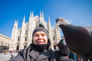 Seyahat, tatil ve kış tatil kavramı - mutlu adamı kabul selfie fotoğraf komik güvercinler ile Duomo Milan Katedrali önünde