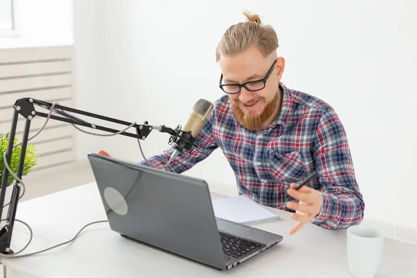 Anfitrión de radio, streamer y blogger concepto - Hombre guapo trabajando como locutor de radio en la estación de radio sentado frente al micrófono — Foto de Stock