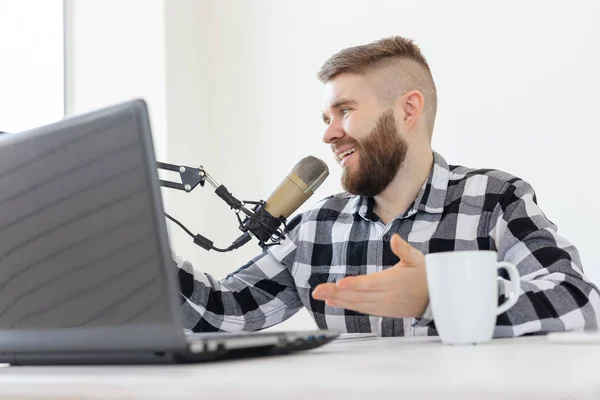 Radio, DJ, blogging y el concepto de la gente - Sonriente hombre sentado frente al micrófono, host en la radio — Foto de Stock