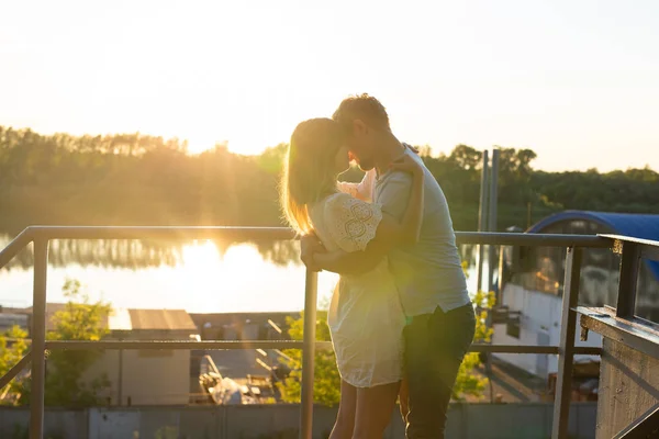 Uomo e donna che si abbracciano al tramonto sulla natura. Coppia in romantico abbraccio — Foto Stock