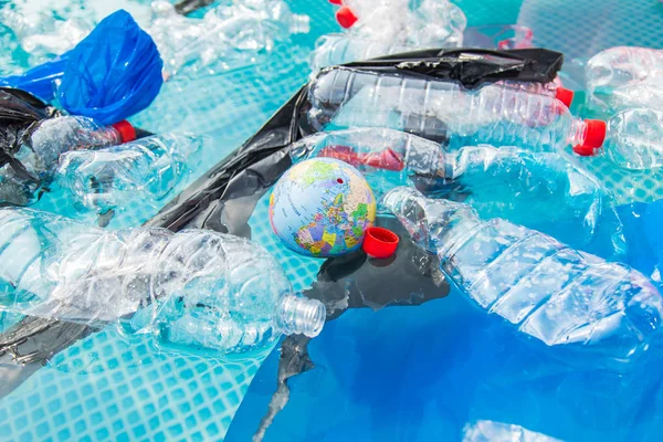 ウファ、ロシア - 2019年7月25日 : ゴミ、プラスチックリサイクル、汚染、環境コンセプトの問題 - 水環境におけるプラスチックゴミ汚染、地球地球がゴミ箱に浮かんでいる — ストック写真