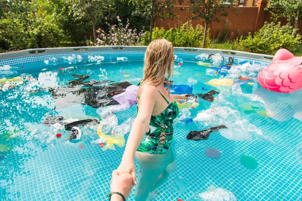 Ecologia, lixo plástico, emergência ambiental e poluição da água - chumbo menina em uma piscina com lixo — Fotografia de Stock