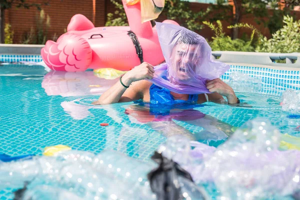 Ecologie, plastic prullenbak, milieu nood en watervervuiling-schreeuwen man met een plastic zak over zijn hoofd in een vuile zwembad — Stockfoto