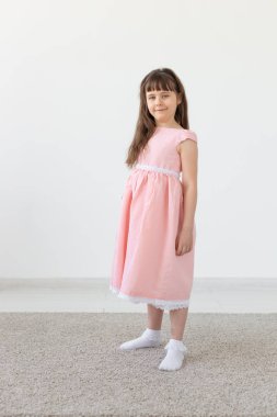 Küçük kız bir model, stüdyoda pembe bir elbise içinde