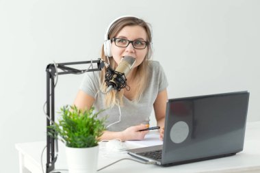 Radyo, Dj, bloglama ve insan kavramı - Gülümseyen kadın mikrofon önünde oturan, radyo da ev sahibi