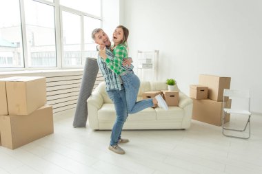 Denim pantolon genç çift hareket sırasında yeni dairede sevincini kucaklayan. Yeni konut için housewarming ve kredi kavramı.