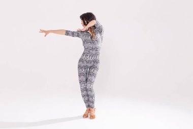 Latin dansı, striptiz dansı, çağdaş ve bachata bayan konsepti - doğaçlama dans eden ve uzun saçlarını beyaz arka planda gezdiren kadın